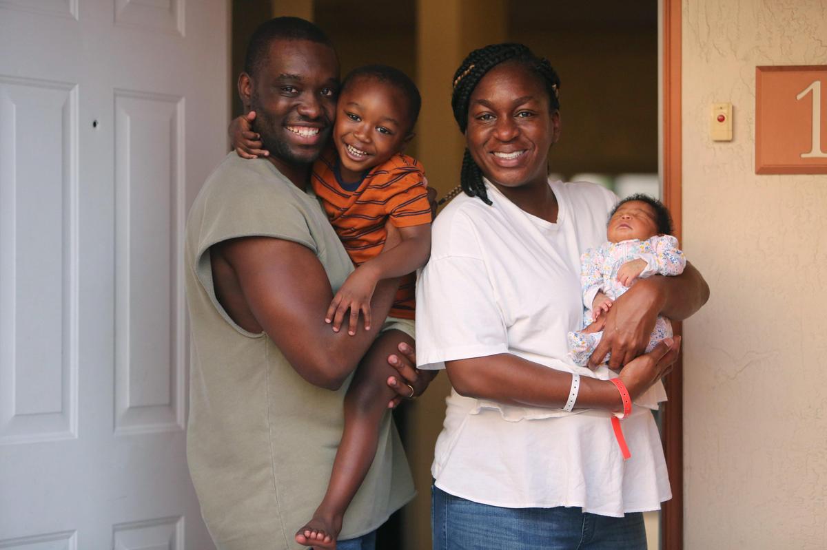 The Costume Family stands in the doorway of their Miami Gardens townhome after bringing their baby daughter Remy home from the hospital on May 18, 2020. From left: Jean Costume, 3-year-old son Urih, wife Alena and daughter Remy.