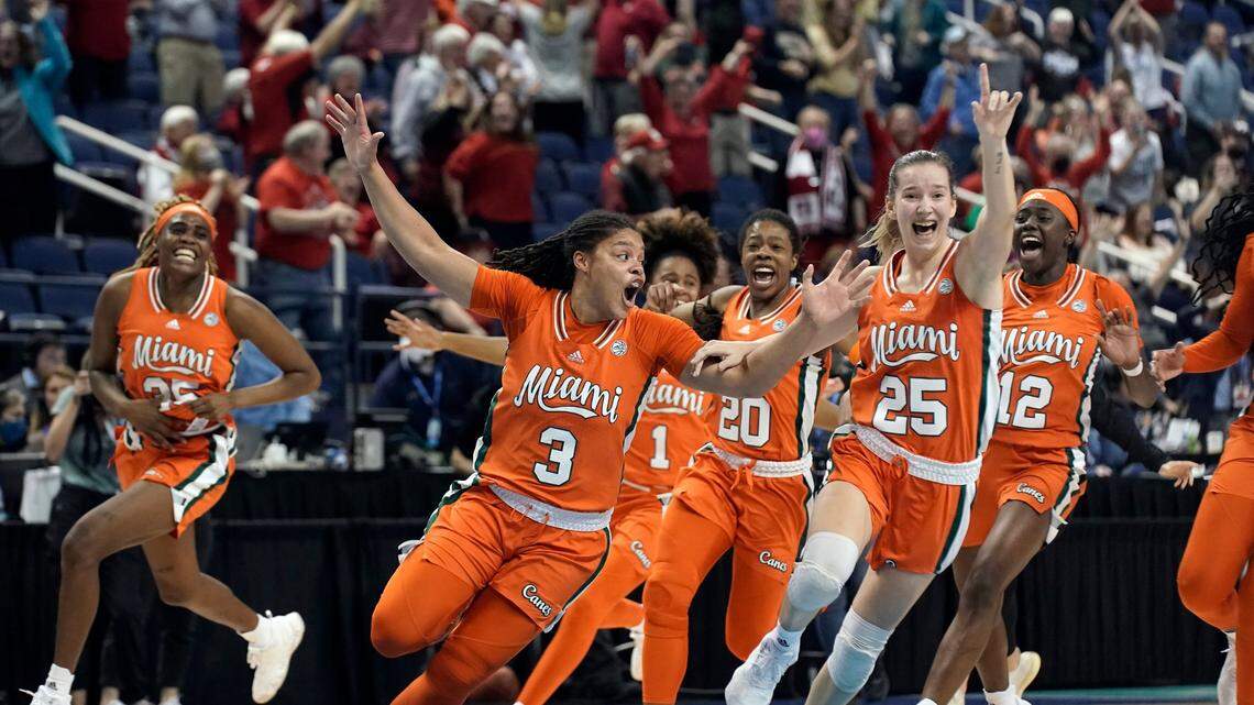 Miami forward Destiny Harden (3) celebrates her game-winning shot with the team following an NCAA college basketball quarterfinal game against Louisville at the Atlantic Coast Conference women’s tournament in Greensboro, N.C., Friday, March 4, 2022. (AP Photo/Gerry Broome)