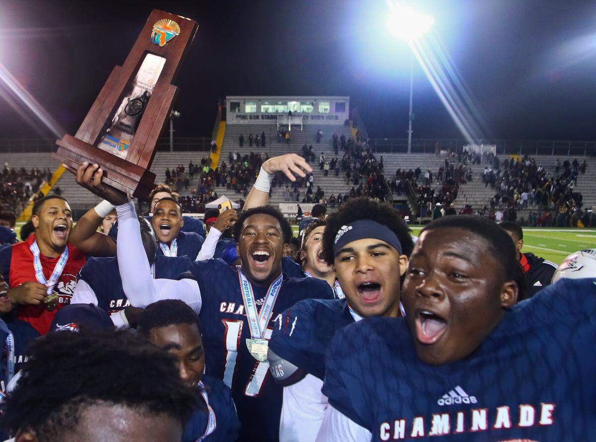Chaminade-Madonna tight end Claude Larkins, holding the trophy, defensive end Kijuan Reid-Jacques and defensive tackle Allan Haye, Jr. celebrate after their FHSAA Class 3A Football State Championship against Florida High Friday, Dec. 6, 2019 in Tallahassee, Fla. Chaminade-Madonna won 35-20.