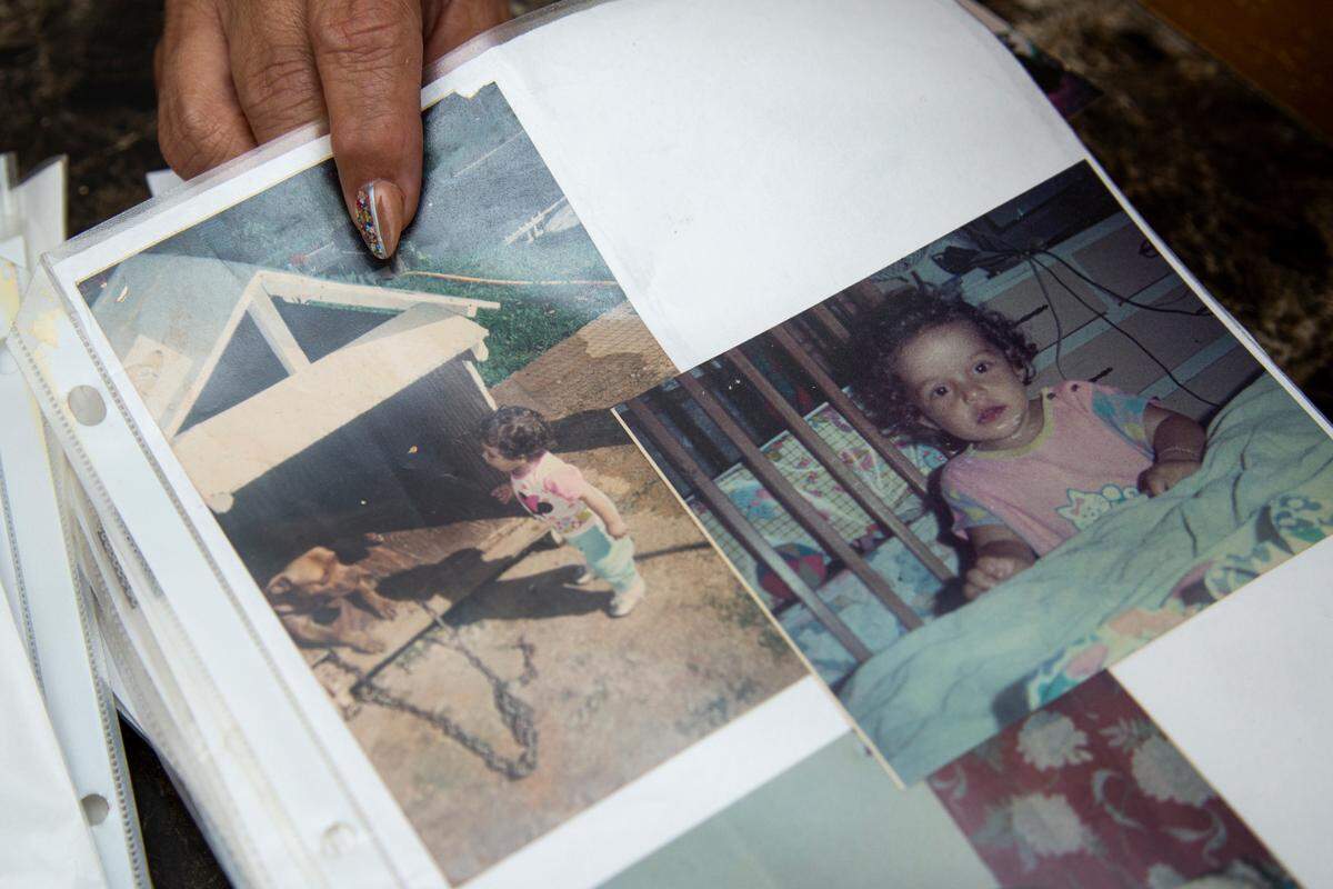 Elba Santos, mother of Angie González, shows photos from a large binder filled with images of her daughter that she has been making for years on March 21, 2021.
