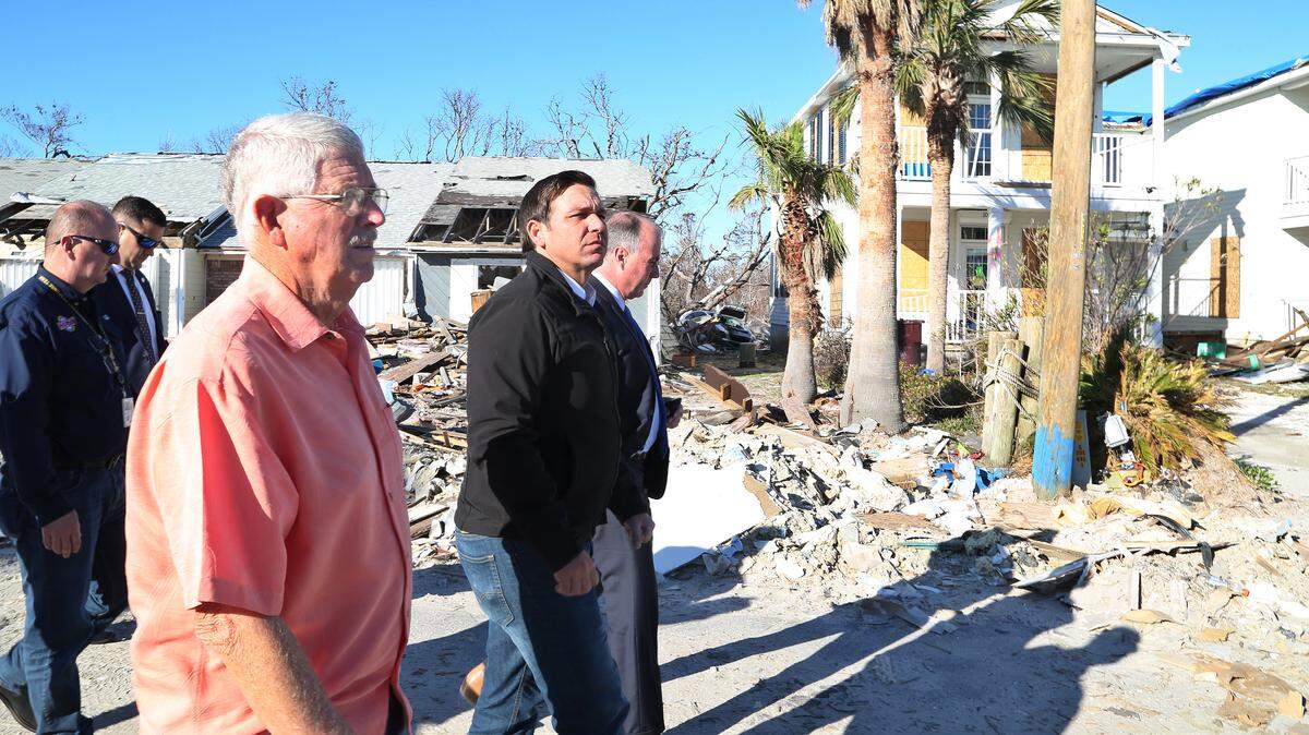SCOTT KEELER | Times Al Cathey, Mayor of Mexico Beach, left, shows Florida Governor Ron DeSantis, center, some of the destruction from Hurricane Michael along Canal Parkway, Wednesday, January 9, 2018.