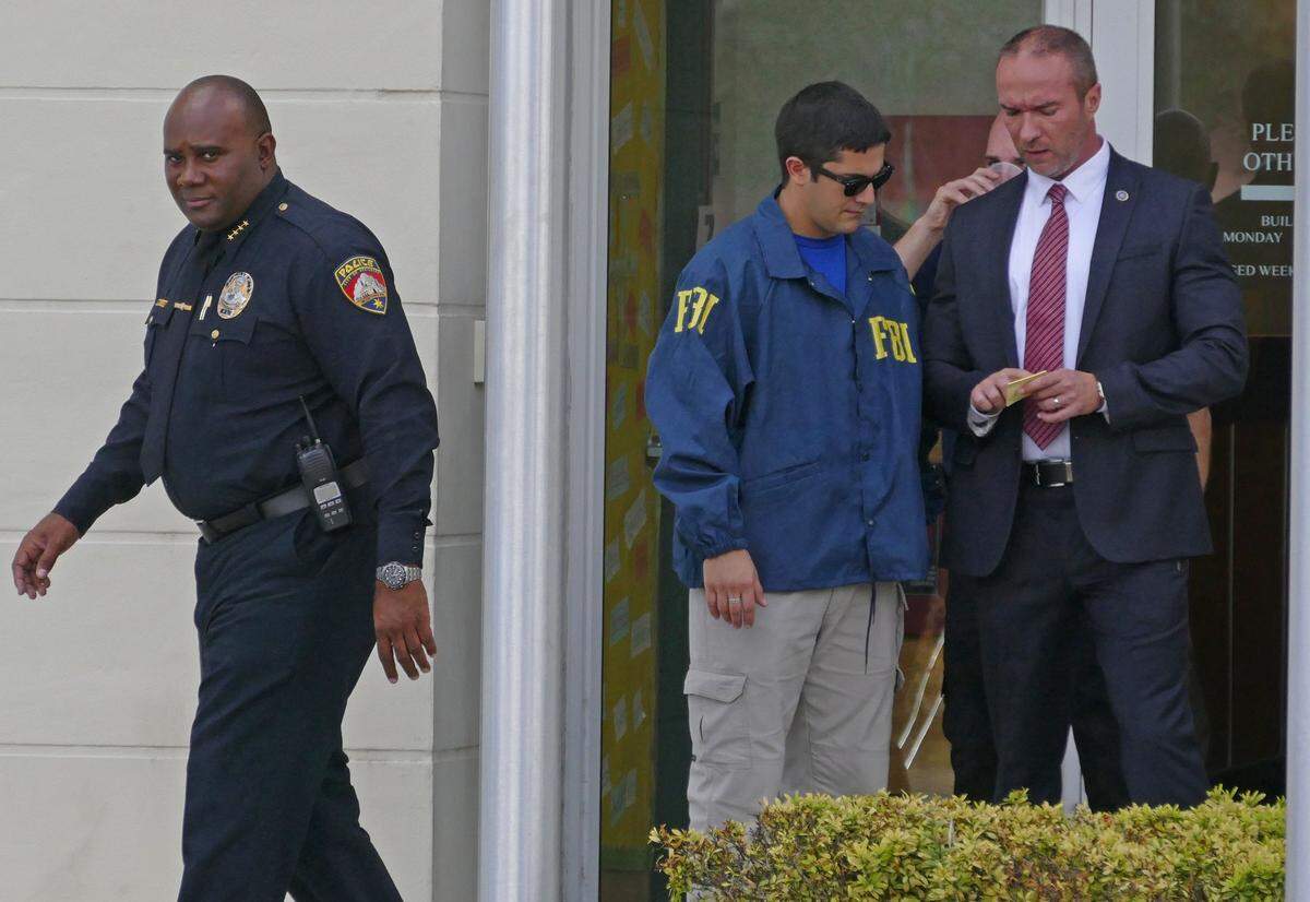 Police chief James Dobson, left, walks out of the City of Opa-locka Municipal Complex after an FBI raid in March.