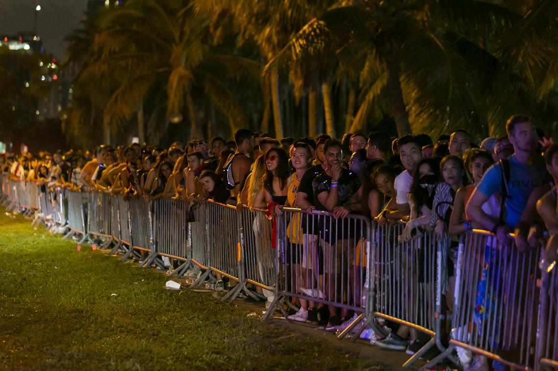 Festival goers line up to board shuttle buses headed toward different drop-off points early Sunday morning after they attended the second day of the 2019 Ultra Music Festival.