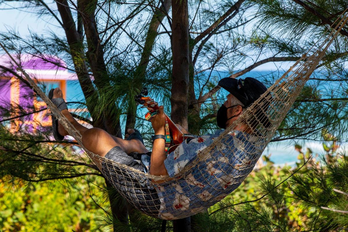 North Beach resident Daniel Goldman, 62, plays his banjo ukulele as he reclines in a hammock on a sandy hill near North Beach Oceanside Park in Miami Beach, Florida, on Tuesday, Jan. 26, 2021. As part of construction of the final segment of the city’s beachwalk, which will span the seven-mile Atlantic coast, the sandy hill will be dug up and dispersed throughout the beachwalk extension.