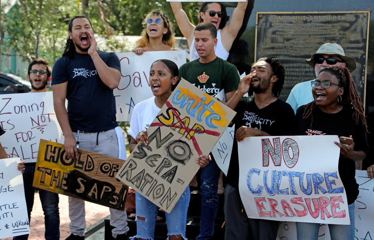 Neighbors protest a proposed $1 billion Magic City Special Area Plan in Little Haiti as they gather by the Toussaint L’Ouverture statue in Miami on Thursday.