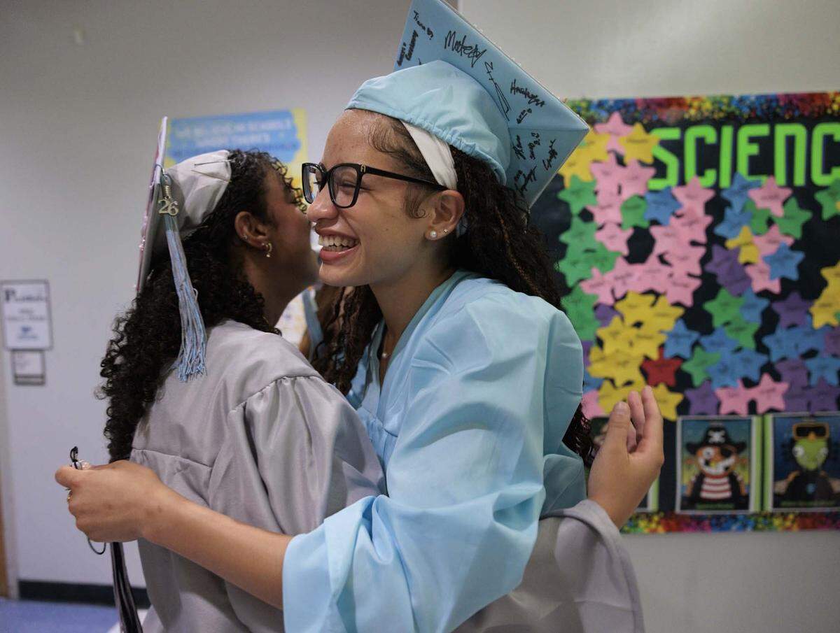 Adeola Alebiosu, right, who flew in from Illinois, hugs an old friend after the alumni walked through the halls of their elementary school, Panther Run Elementary, on Monday, June 1, 2026, in Pembroke Pines, Fla. The school invited graduating alumni, from as far as Illinois, to come and walk through their former elementary school to celebrate their high school graduation before it closes. 