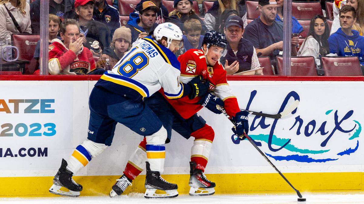 Florida Panthers center Nick Cousins (21) is checked by St. Louis Blues center Robert Thomas (18) during the second period of an NHL game at Amerant Bank Arena in Sunrise, Florida, on Thursday, December 21, 2023.