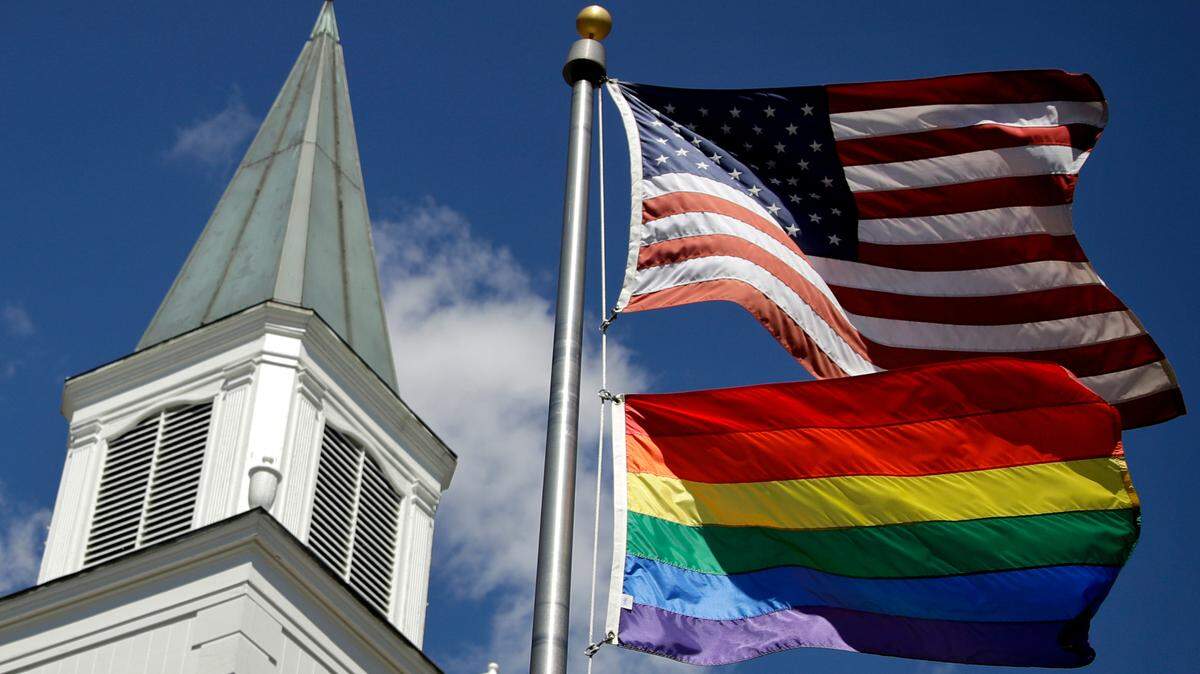 In this April 19, 2019 file photo, a gay pride rainbow flag flies along with the U.S. flag in front of the Asbury United Methodist Church in Prairie Village, Kan.