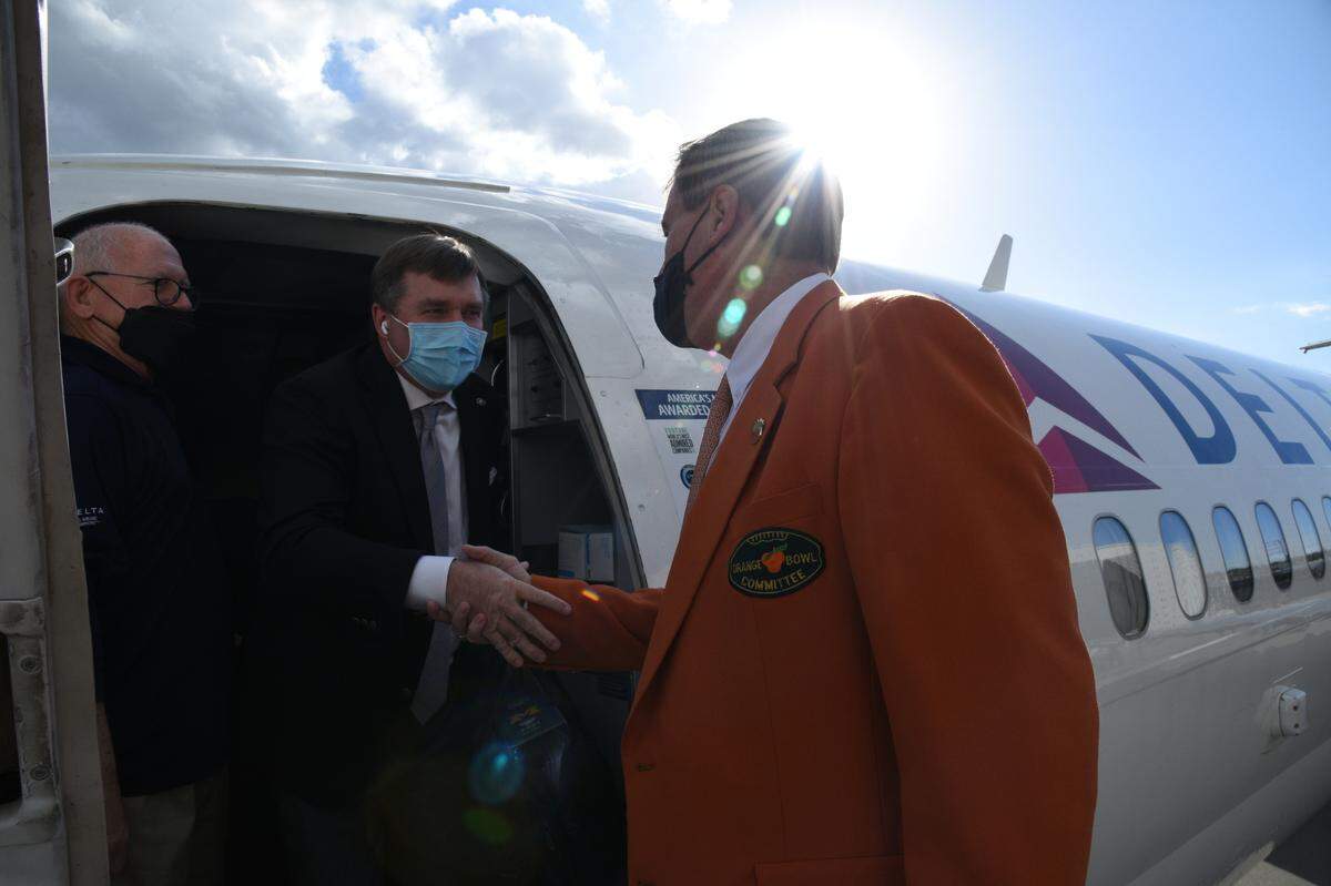 Georgia Bulldogs coach Kirby Smart is greeted as he gets off a plane at Miami International Airport on Sunday, Dec. 26, 2021. Georgia will face the Michigan Wolverines in the Orange Bowl for a College Football Playoff semifinal.