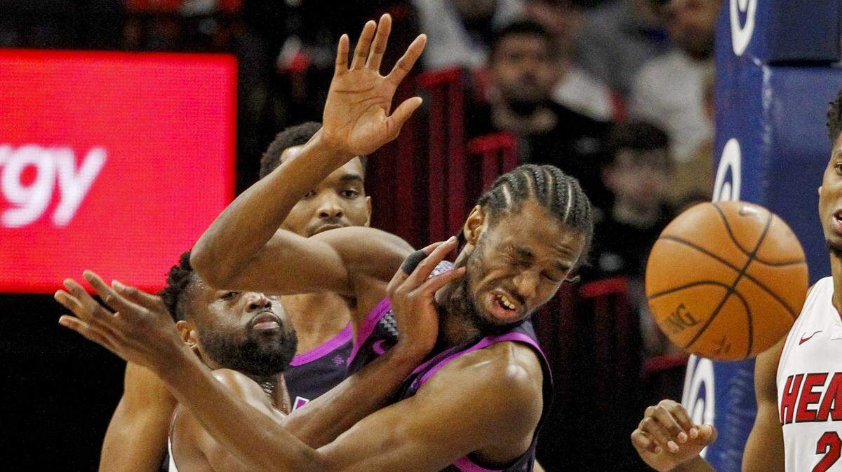 Miami Heat guard Dwyane Wade, front left, knocks the ball away from Minnesota Timberwolves forward Andrew Wiggins (22) in the first quarter of an NBA basketball game Friday, April 5, 2019, in Minneapolis. (AP Photo/Bruce Kluckhohn)