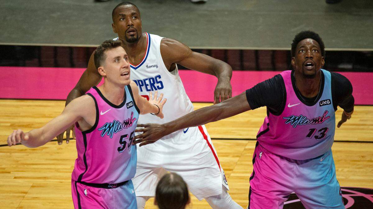 Los jugadores del Heat, Bam Adebayo (13) y Duncan Robinson (55), luchan por una posición debajo el aro con el delantero de poder de los Clippers, Serge Ibaka (9), el jueves 28 de enero de 2021 en Miami.