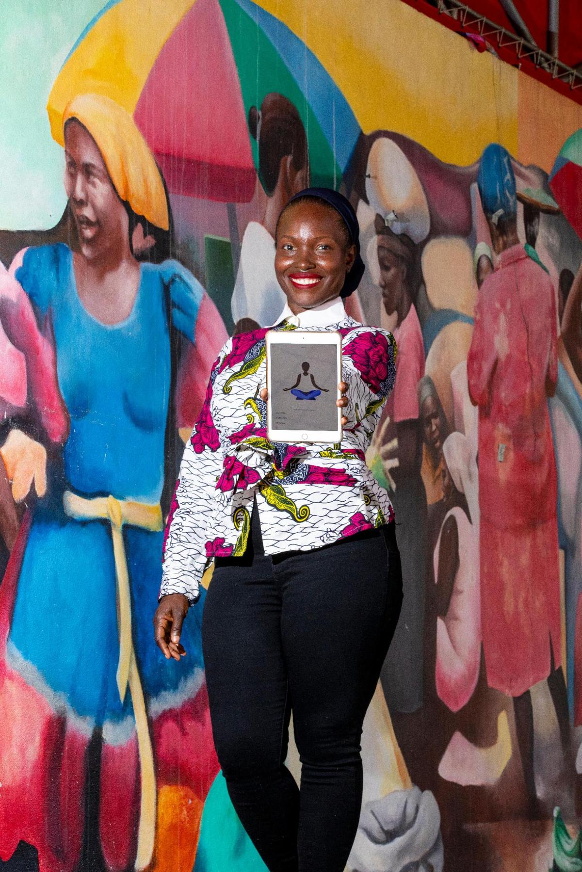 Entrepreneur Nzingah Oniwosan shows off her self-care application, 365Zing, which helps users become healthier through meal plans, yoga classes and therapy, at the Little Haiti Cultural Center in the Little Haiti neighborhood of Miami, Florida, on Friday, August 13, 2021. Oniwosan was one of thousands of Black Americans who started new businesses in 2020, a year that saw more Black entrepreneurial growth than at any time in the last 25 years, according to the Kauffman Foundation’s annual report.