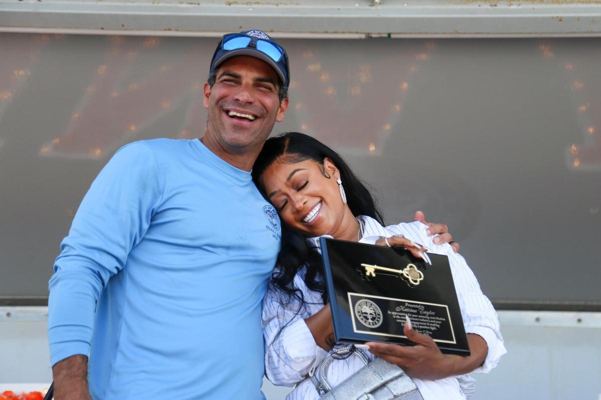 American rapper Katrina Taylor, known professionally as Trina, reacts as she receives the key to the city from City of Miami Mayor Francis X. Suarez during a block party on NW 15th Avenue between NW 63rd and 65th Street, celebrating Trina Day in Liberty City, Florida, on Saturday, May 14, 2022.