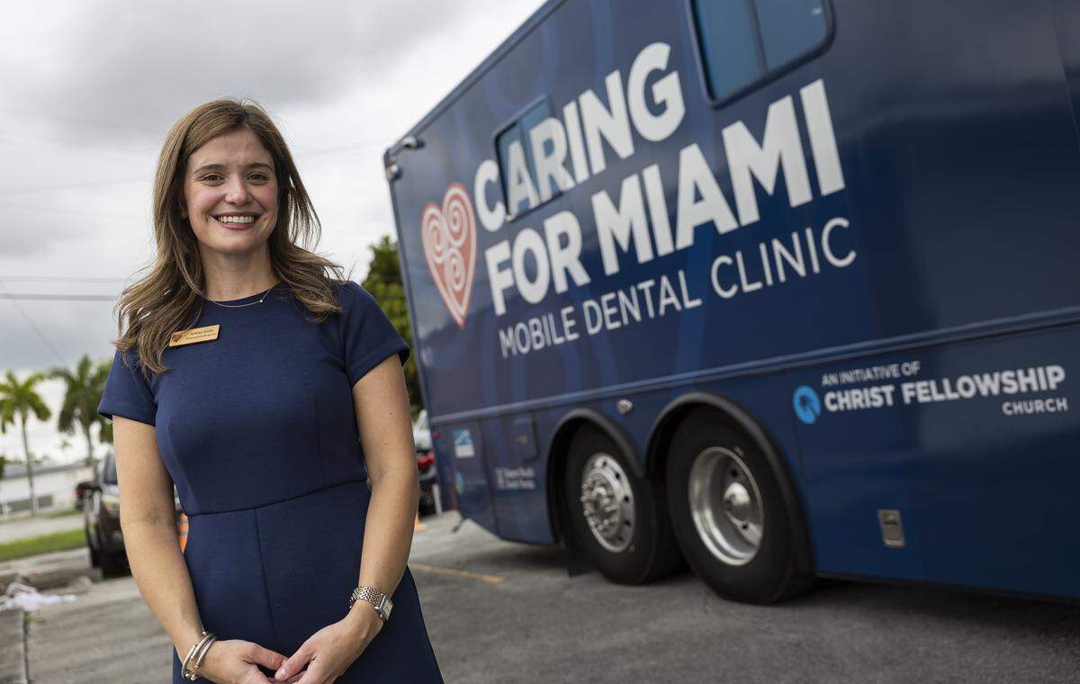 Ashley Giritli, executive director of Caring for Miami, is photographed next to the Mobile Dental Clinic in Opa-locka. Caring for Miami is partnering with UHI CommunityCare Clinic to provide free dental care for uninsured and low-income residents.