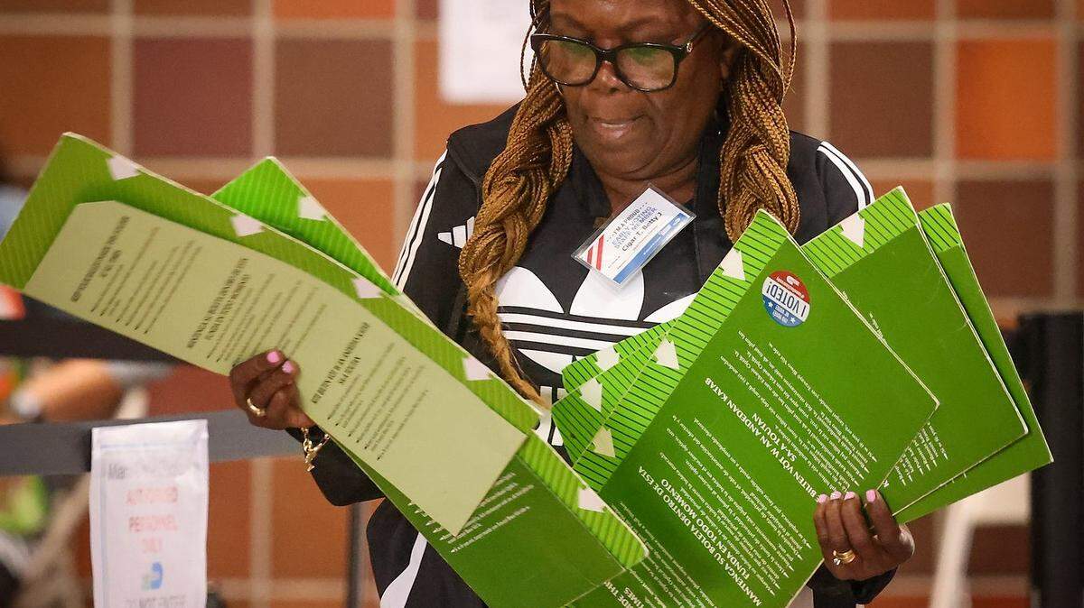 Poll worker at the end of a voting day gathers up used voting materials during the primary early voting period in August 2024 in Miami-Dade County.