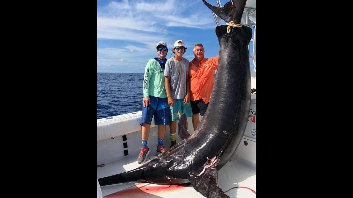Captain Nick Stanczyk, his mate, Konnor Ross, and Bill Lussier stand next to a 757.8-pound swordfish Lussier reeled in on Stanczyk’s boat March 31, 2019, off Islamorada.