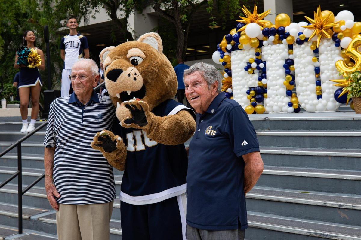 Jose Selma, 93, FIU Class of 1974, left, poses for a photo with FIU mascot Roary the Panther and Angel Vega, 87, FIU Class of 1974, during a toast to celebrate FIU’s 50th anniversary on the steps of the Charles Perry Building at the Modesto A. Maidique Campus in Miami, Fla., on Monday, Sept. 19, 2022.