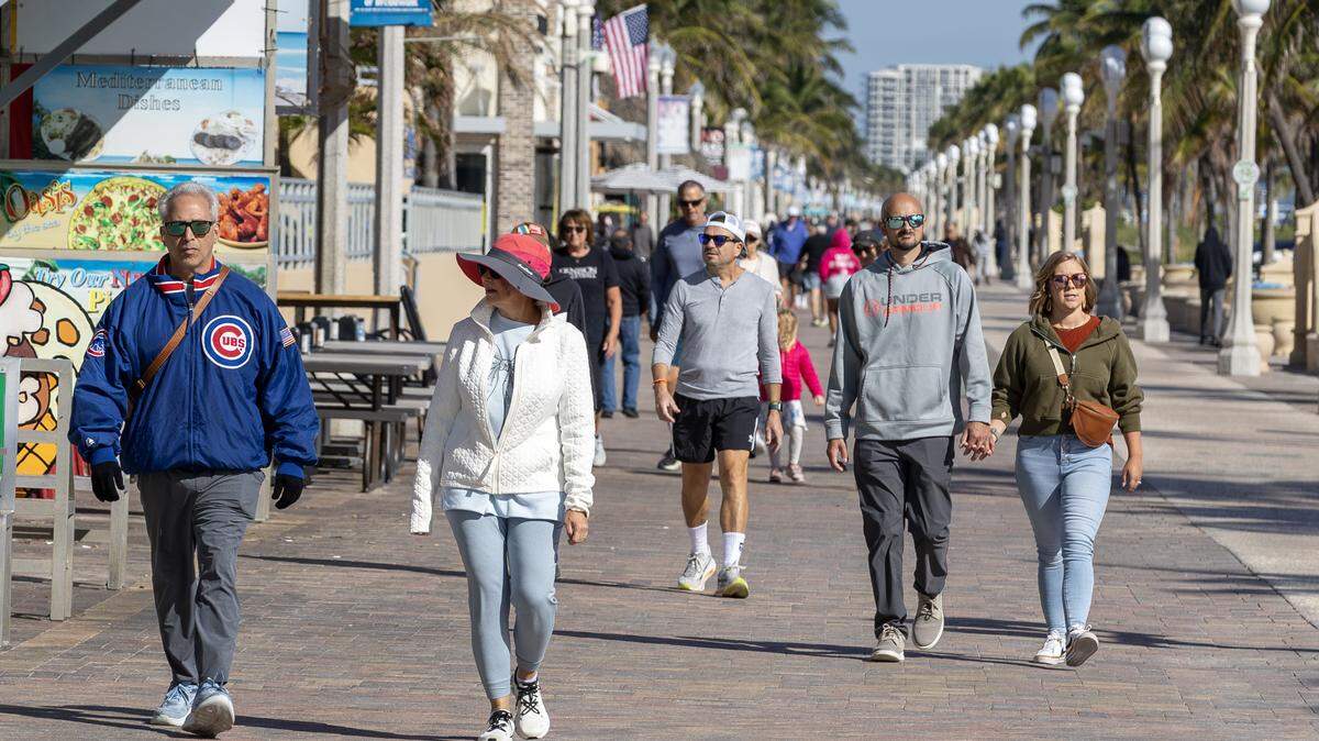 South Florida will look like this again as cooler weather heads to town. Here, people bundled up against the chill on Hollywood Broadwalk during another cool spell in November.
