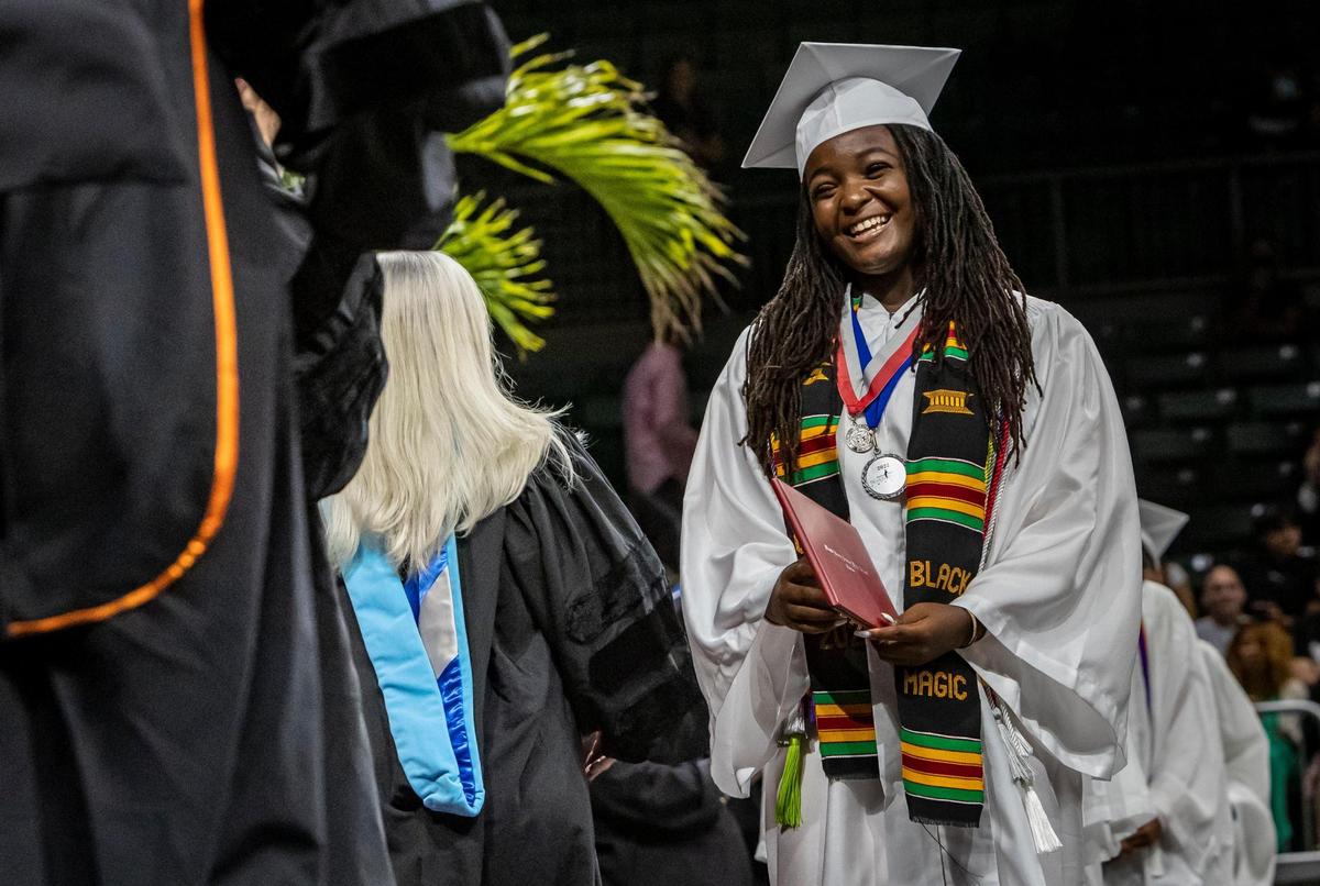 Coral Gables, June 1, 2022 - Ashley Adirika greets teachers and other guests after receiving her diploma during commencement ceremonies in the Watsco Center at the University of Miami. Ashley was accepted to all Ivy League schools and will be attending Harvard in the fall. She was also a Silver Knight winner.