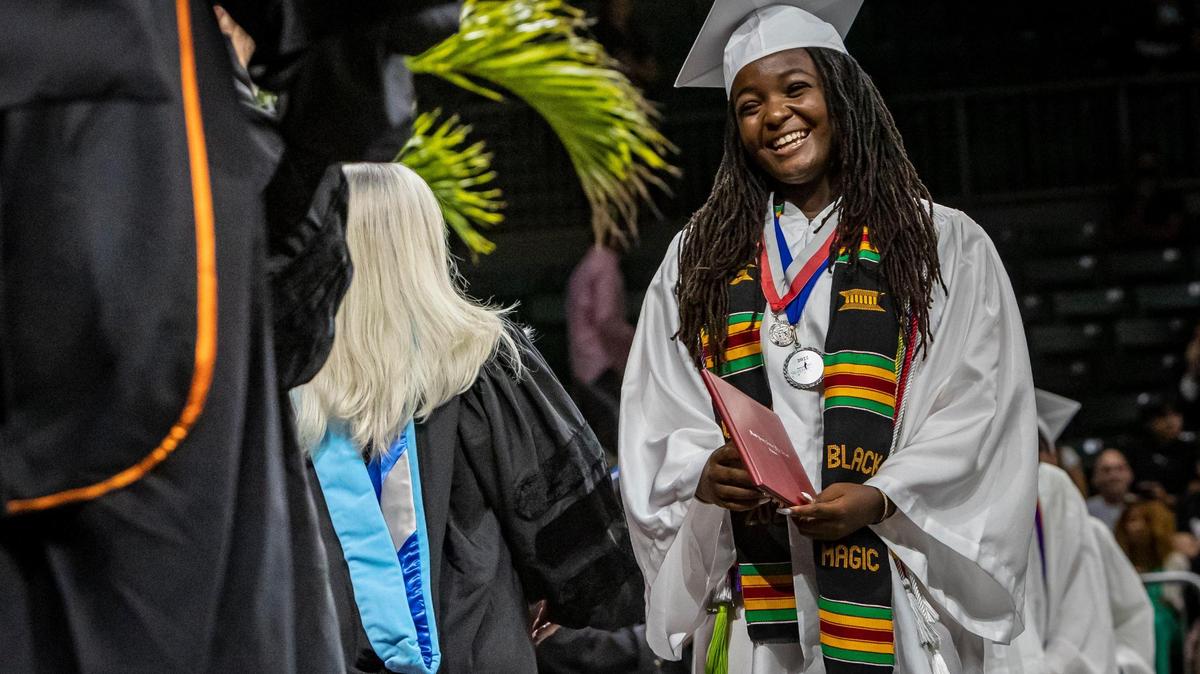 Ashley Adirika greets teachers and other guests after receiving her diploma during commencement ceremonies in the Watsco Center at the University of Miami in Coral Gables, June 1, 2022. Ashley was accepted to all eight Ivy League schools and will be attending Harvard in the fall. She was also a Silver Knight winner.