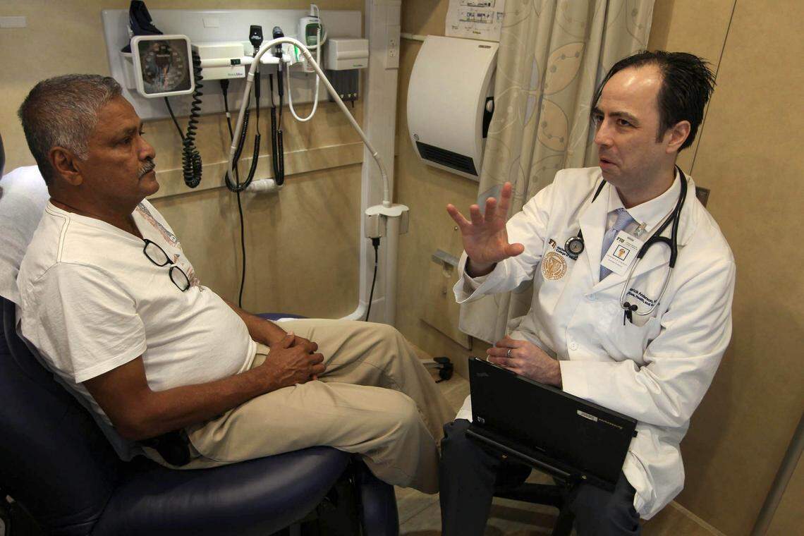 Dr. Fred Anderson, right, consults with his patient, Sharma Boboolal in a mobile clinic in Miami Gardens. Anderson is a family doctor who said his job caring for uninsured and low-income patients, including many immigrants, has become more difficult due to proposed changes to a federal citizenship rule called public charge and a rise in anti-immigrant rhetoric.