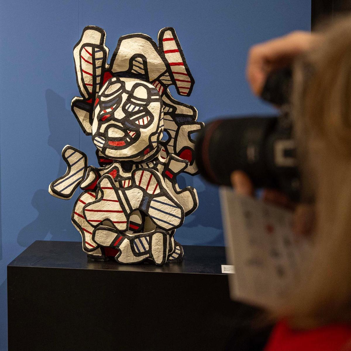 A guest takes a photo of ‘Buste aux envoys’ by Jean Dubuffet during Art Miami at One Herald Plaza on Tuesday, Dec. 3, 2024, in Miami, Fla.