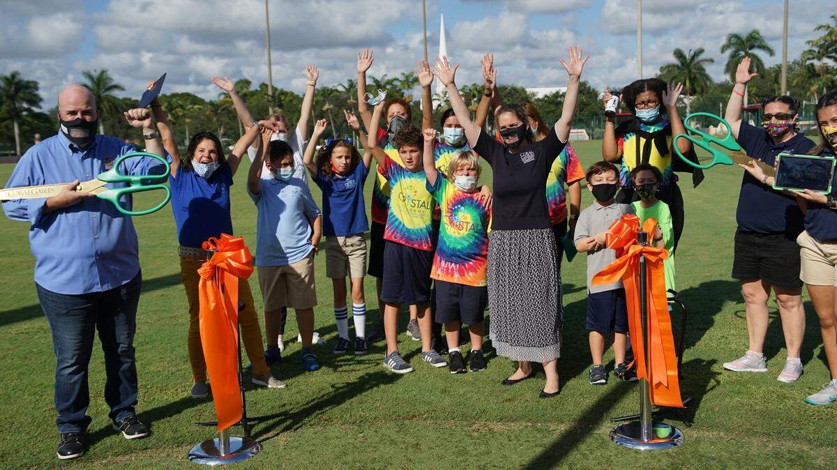 Coral Gables Community Recreation Director Fred Couceyro, left, with Coral Gables Assistant Parks & Recreation Director Carolina Vester, middle, celebrate the opening of the free Magical Park with Crystal Academy staff and students.