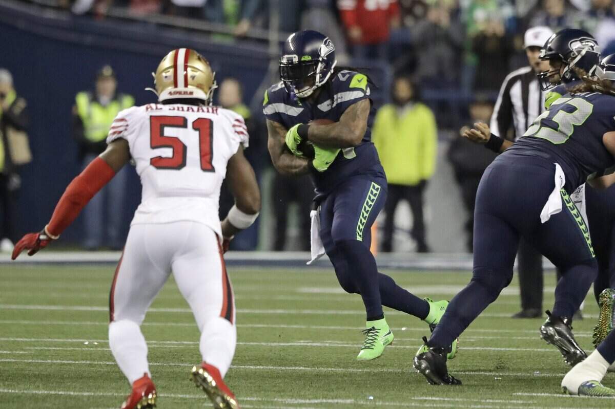 Seattle Seahawks running back Marshawn Lynch (24) carries as San Francisco 49ers’ Azeez Al-Shaair (51) heads in during the first half of an NFL football game, Sunday, Dec. 29, 2019, in Seattle. (AP Photo/Ted S. Warren)