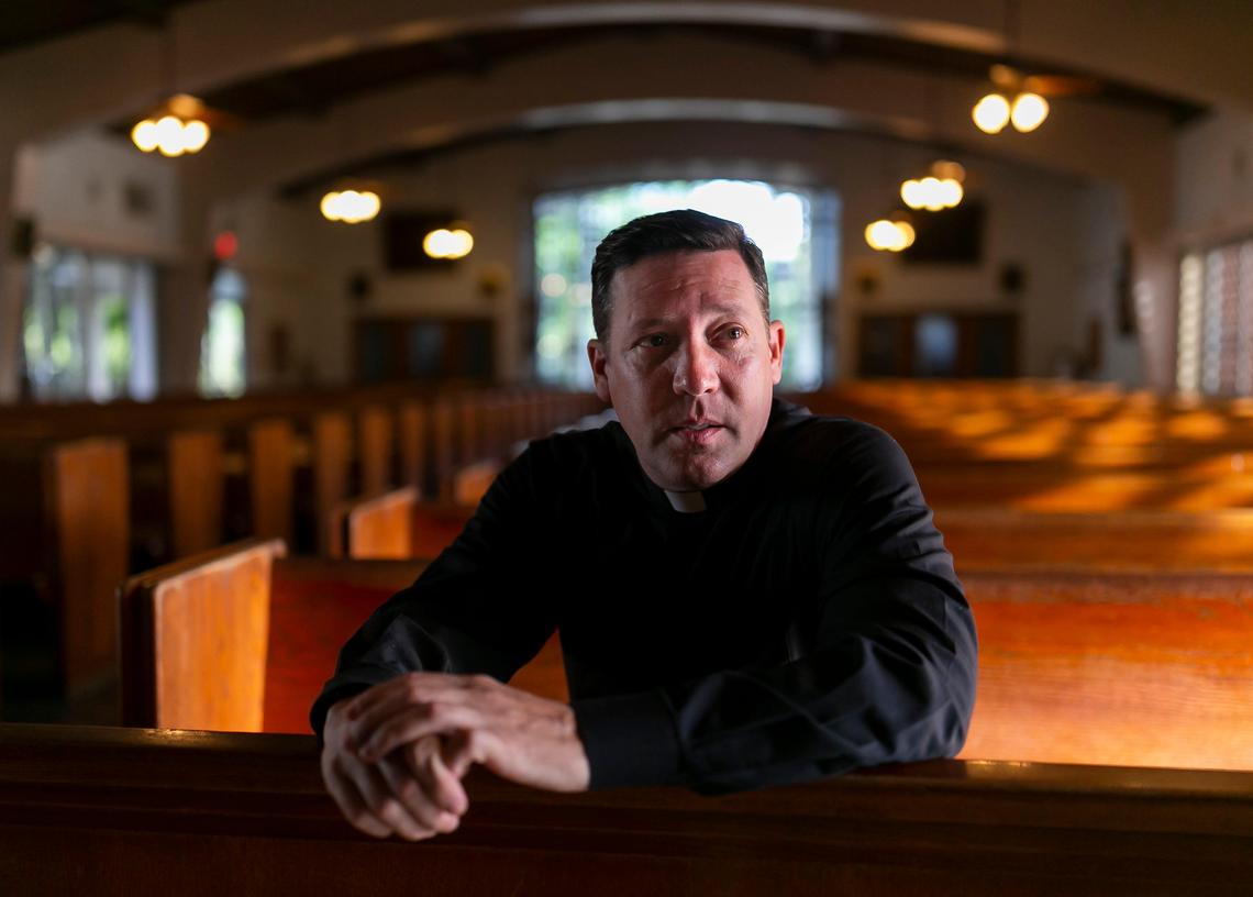 Father Richard Vigoa, the administrator of St. Augustine Church and Catholic Student Center, sits at the pew in his church in Coral Gables, Florida on Saturday, March 21, 2020. Due to COVID-19, churches have had to use technology and different ideas to help reach their parishioners.