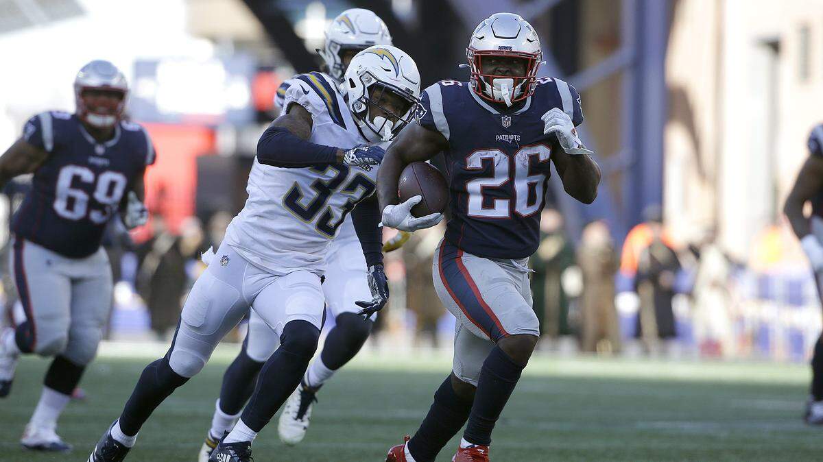 New England Patriots running back Sony Michel (26) runs away from Los Angeles Chargers free safety Derwin James (33) during the first half of an NFL divisional playoff football game, Sunday, Jan. 13, 2019, in Foxborough, Mass.