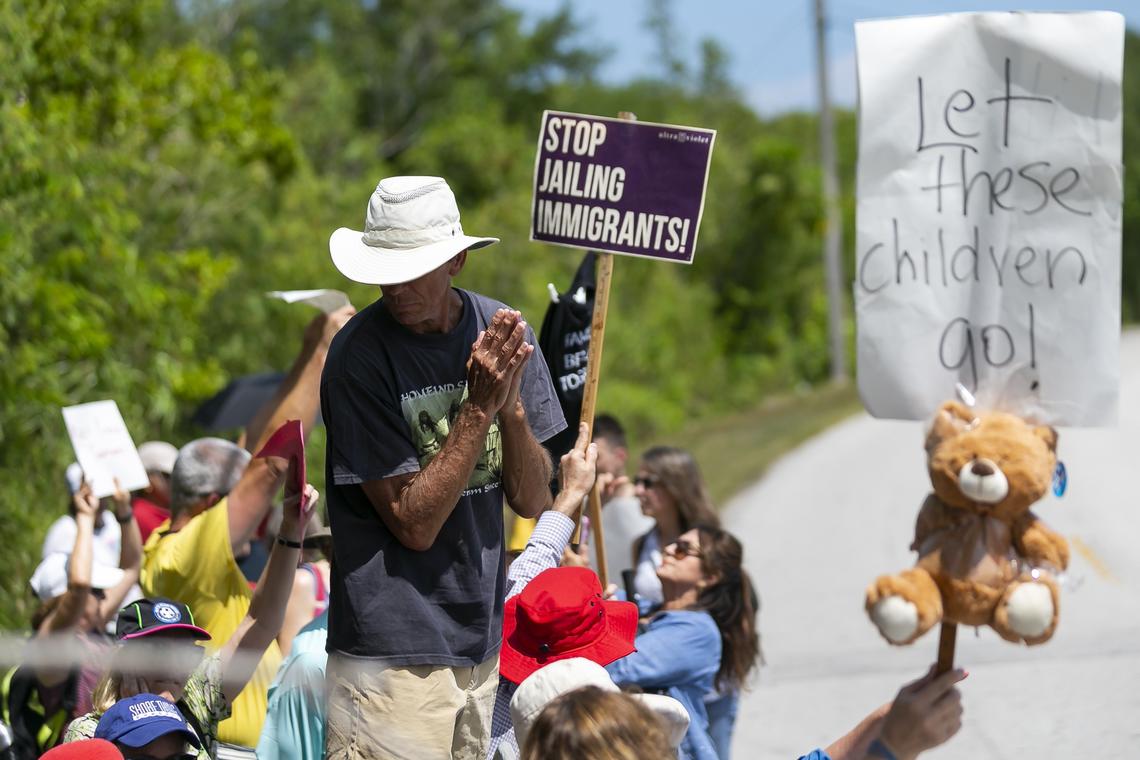 Tom Southern, 68, center, gathers with a group of activists protesting the Homestead Temporary Shelter for Unaccompanied Children during Good Friday in Homestead, Florida on April 19, 2019.