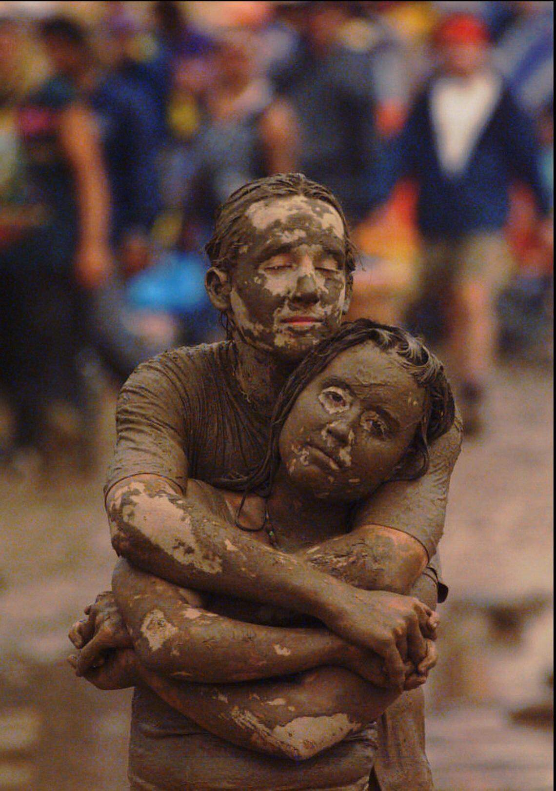 Kyle Keyser, 21, wraps his arms around Linda Latzlsberger, 18, as they listen to the music of Traffic while standing on the mud covered field before the north stage at Woodstock ’94 in Saugerties New York, in this file photo from Aug. 14, 1994.