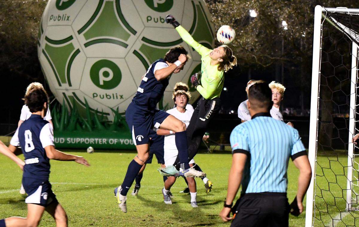 South Walton goalkeeper Graham Wilde blocks a Gulliber Prep shot with his head during the first half while Jacob Lombard (22) and Rodrigo Navarro (12) crash the goal for Gulliver during a FHSAA Class 4A state semifinal game on Thursday at Lake Myrtle Park.