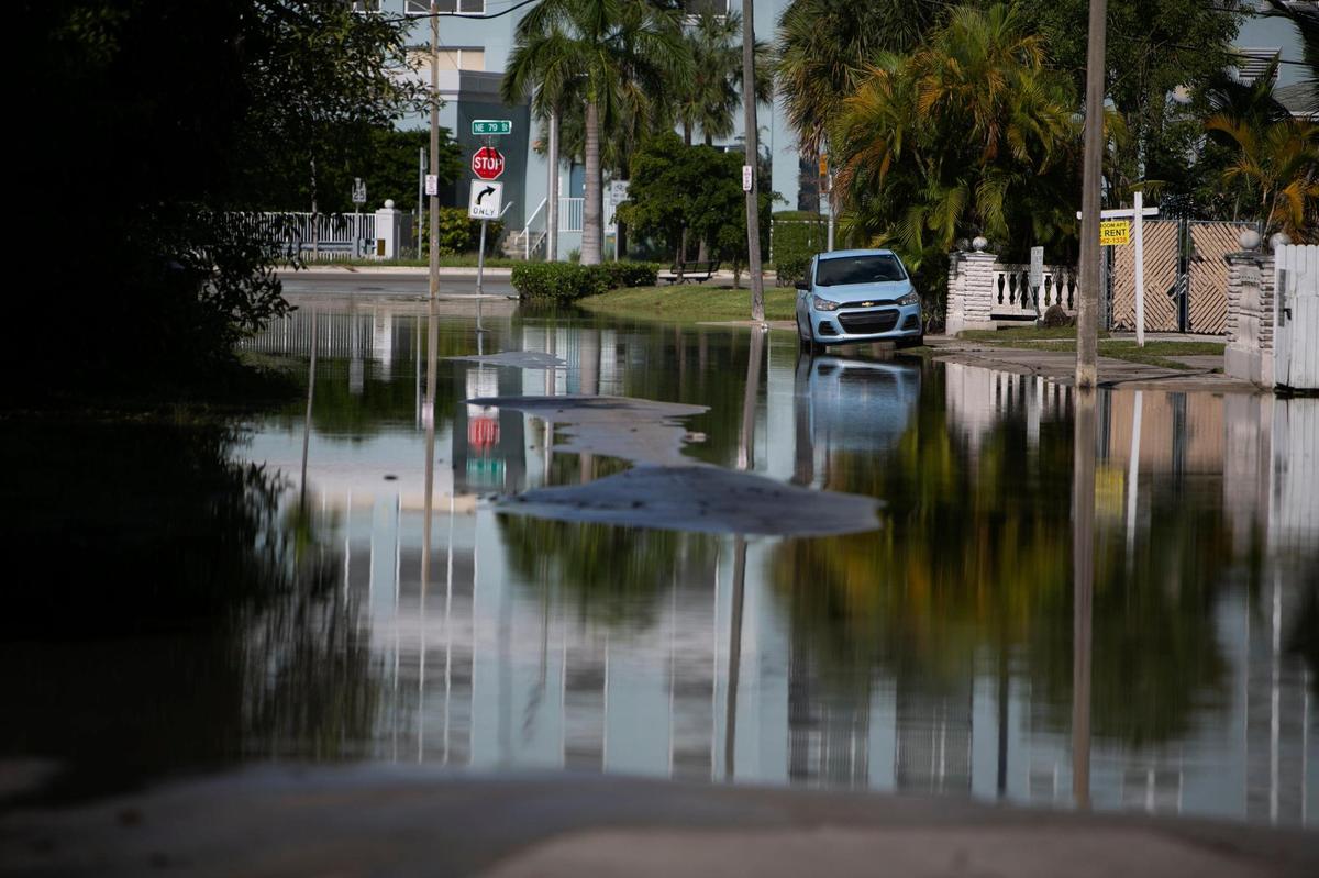 Un auto solitario en una calle inundada de Miami en 2021. Las calles inundadas debido a las mareas reales pudieran ser mucho más comunes a mediados de siglo a medida que el nivel del mar ascienda.