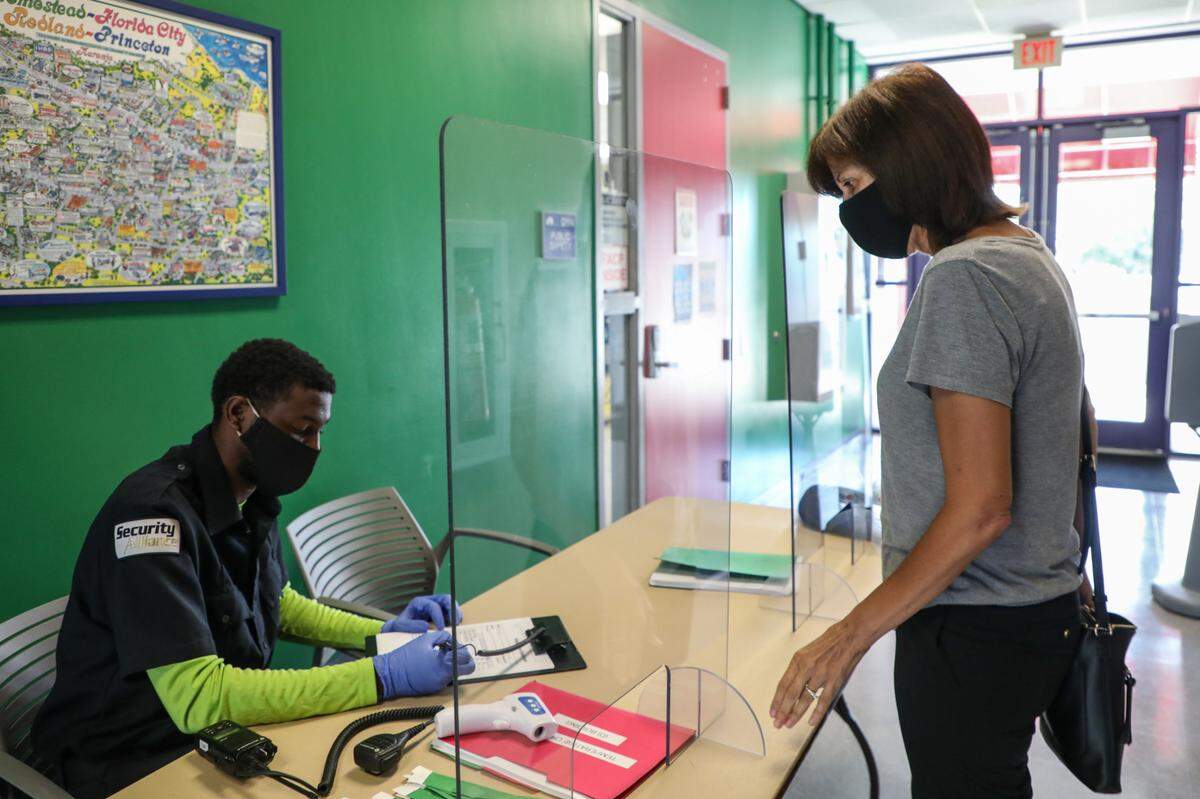 Personal de MDC verifica la temperatura de sus estudiantes y docentes en el puesto de control del Campus de Homestead el 17 de junio de 2020.