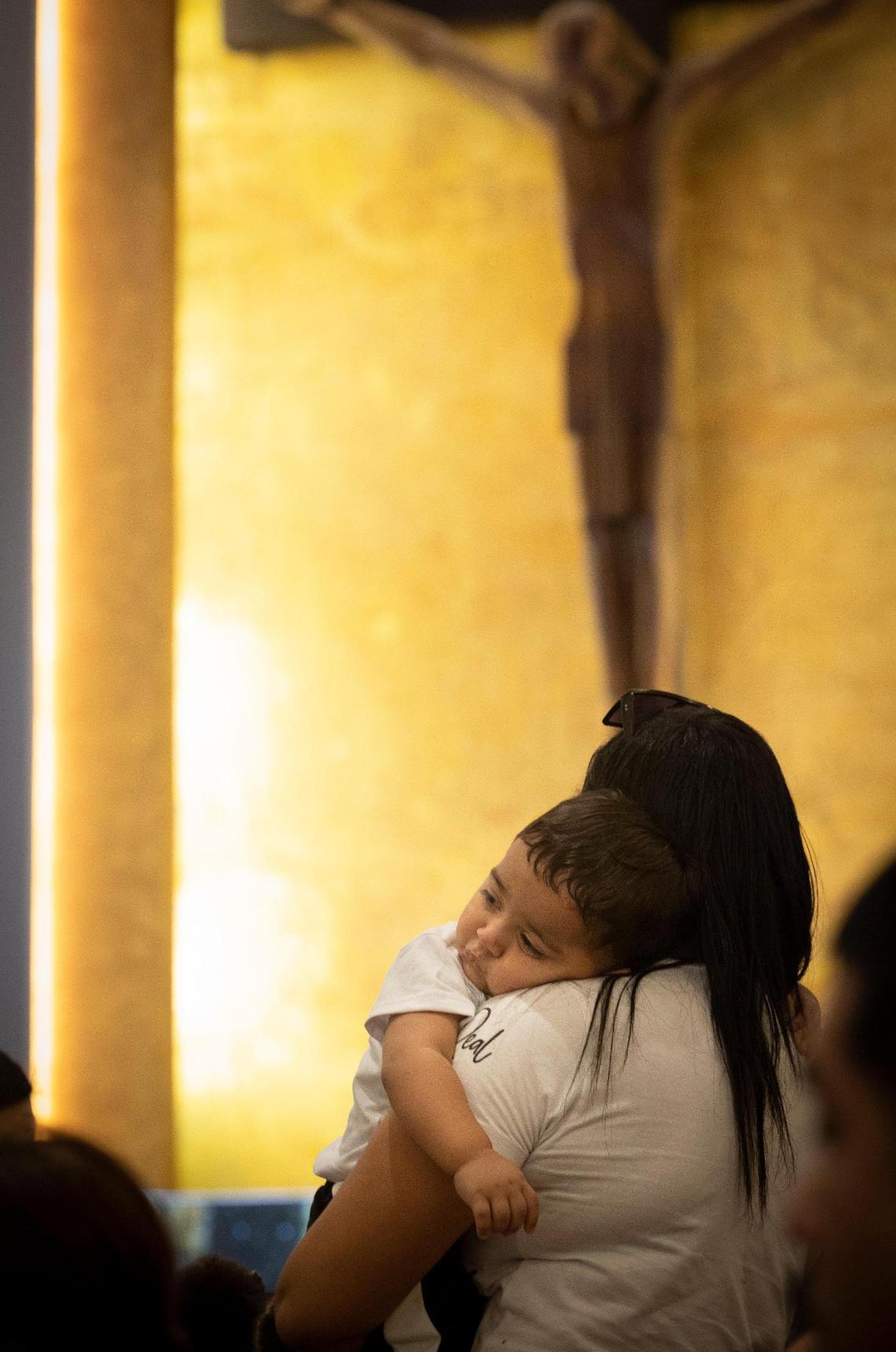 Maria Chirinos holds her son, Jhonder, 1, during mass before his baptism ceremony at Corpus Christi Catholic Church in Miami.