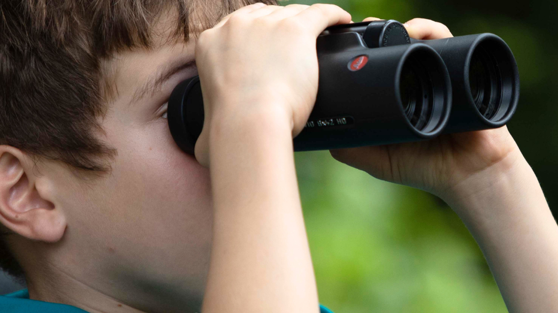  A boy tries out Leica binoculars at the Bird Day nature festival. 

