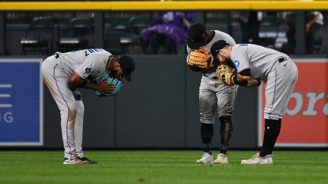 May 24, 2023; Denver, Colorado, USA; Miami Marlins left fielder Bryan De La Cruz (14) Miami Marlins center fielder Jonathan Davis (49) and Miami Marlins right fielder Garrett Hampson (1) bow to each other after the win over the Colorado Rockies at Coors Field. Mandatory Credit: John Leyba-USA TODAY Sports