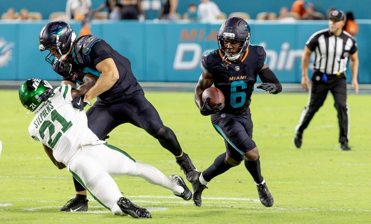 Miami Dolphins wide receiver Malik Washington (6) carries the ball as tight end Tanner Conner (80) blocks New York Jets cornerback Brandon Stephens (21) during the first half of an NFL football game Monday, Sept. 29, 2025, in Miami Gardens, Fla.
