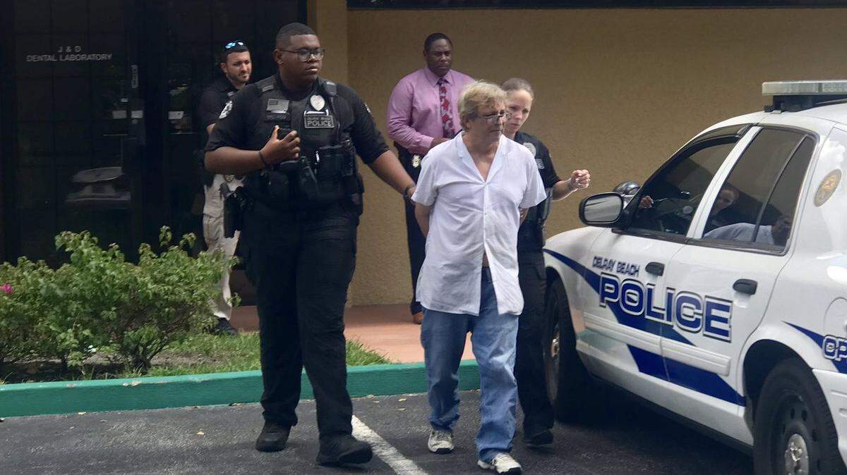 Julian Sadarriaga, 60, was led out of J & D Dental Laboratory in Delray Beach July 1, 2019 by cops, after detectives say he was practicing dentistry without a license.