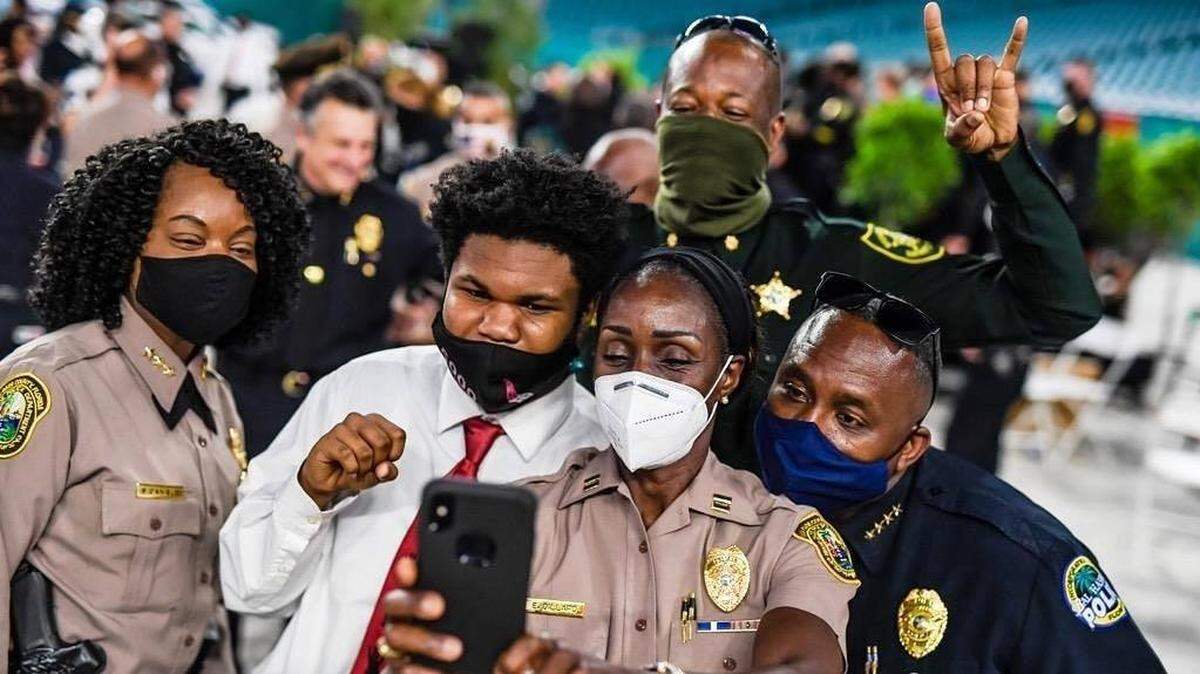 Law-enforcement officers celebrate with 5000 Role Models student George Pickens IV, who last year was named No. 1 academic student in the rising senior class at Miami Northwestern Senior High School. He had a 5.0 GPA.