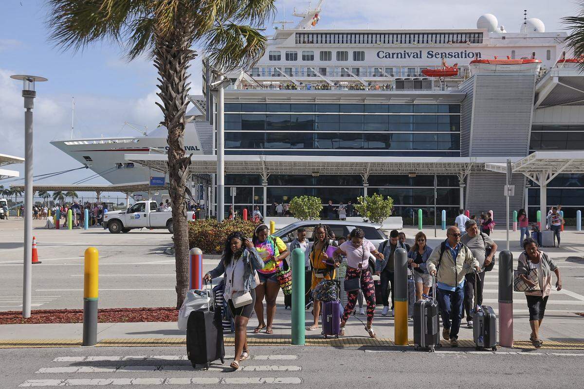 Cruisers disembark from the Carnival Sensation at PortMiami on Monday, March 9, 2020, one day after the U.S. Centers for Disease Control and Prevention advised all Americans to avoid cruise ships because they are exceptionally dangerous for COVID-19 spread.