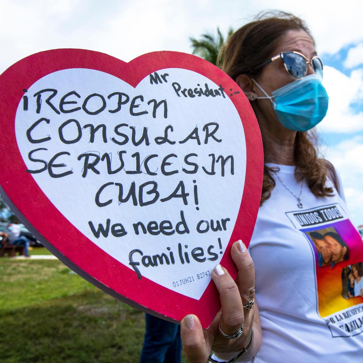 Marietta Medialdea, de 59 años, sostiene una caja de dulces en forma de corazón con un mensaje al presidente Biden para ‘reabrir el consulado en Cuba’ mientras usa una camiseta con una foto de su hijo, a quien no ha visto en más ocho años. Grupos que abogan por la reanudación del programa de reunificación familiar cubana y la reapertura de los servicios de visas en La Habana oraron en la Ermita de la Caridad en Miami, Florida, el domingo 14 de marzo de 2021.