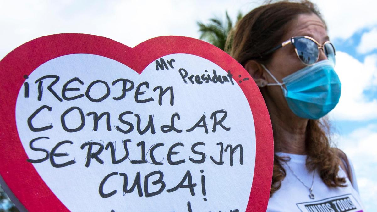 Marietta Medialdea, de 59 años, sostiene una caja de dulces en forma de corazón con un mensaje al presidente Biden para ‘reabrir el consulado en Cuba’ mientras usa una camiseta con una foto de su hijo, a quien no ha visto en más ocho años. Grupos que abogan por la reanudación del programa de reunificación familiar cubana y la reapertura de los servicios de visas en La Habana oraron en la Ermita de la Caridad en Miami, Florida, el domingo 14 de marzo de 2021.