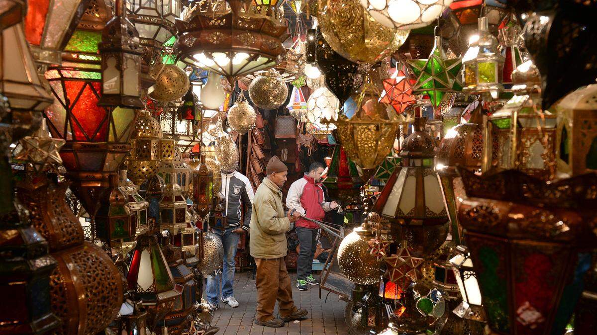 People walk through an alley of a traditional souk in the old Medina of Marrakesh on December 30, 2014.