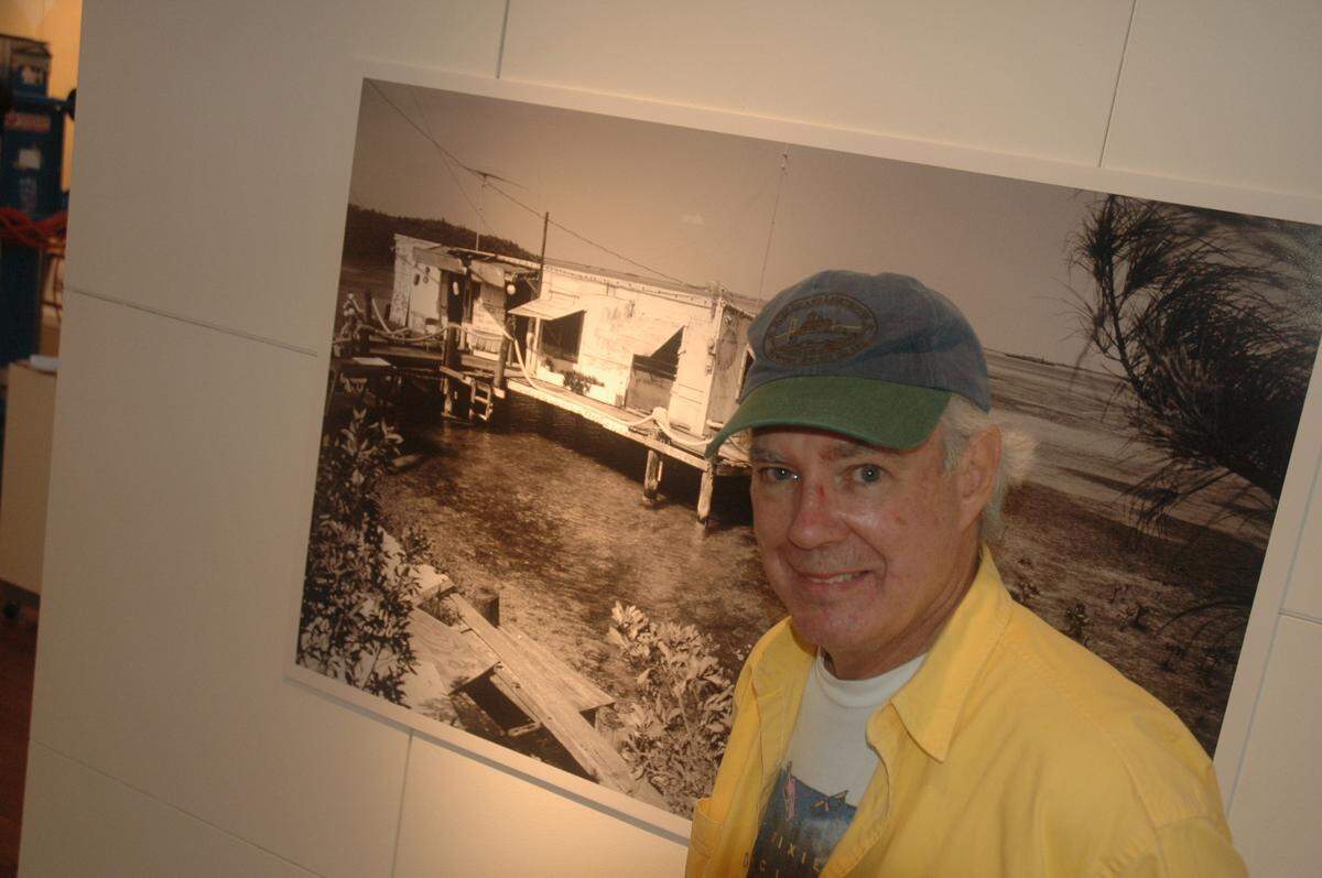 In this file photo from Oct. 30, 2007, author and photographer Tom Corcoran is pictured in front of one of his 70 photographs of Key West that were on exhibit at the historic Custom House in the Southernmost City.
