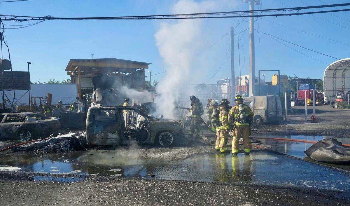 Miami-Dade firefighters working the scene where multiple vehicles were on fire at 11350 NW South River Dr. on Tuesday, Feb. 21, 2023.