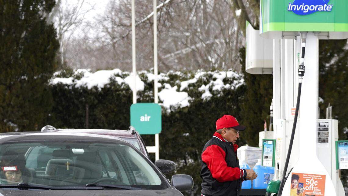 A man checks gas prices at a BP gas station in Libertyville, Ill., Saturday, Feb. 6, 2021.