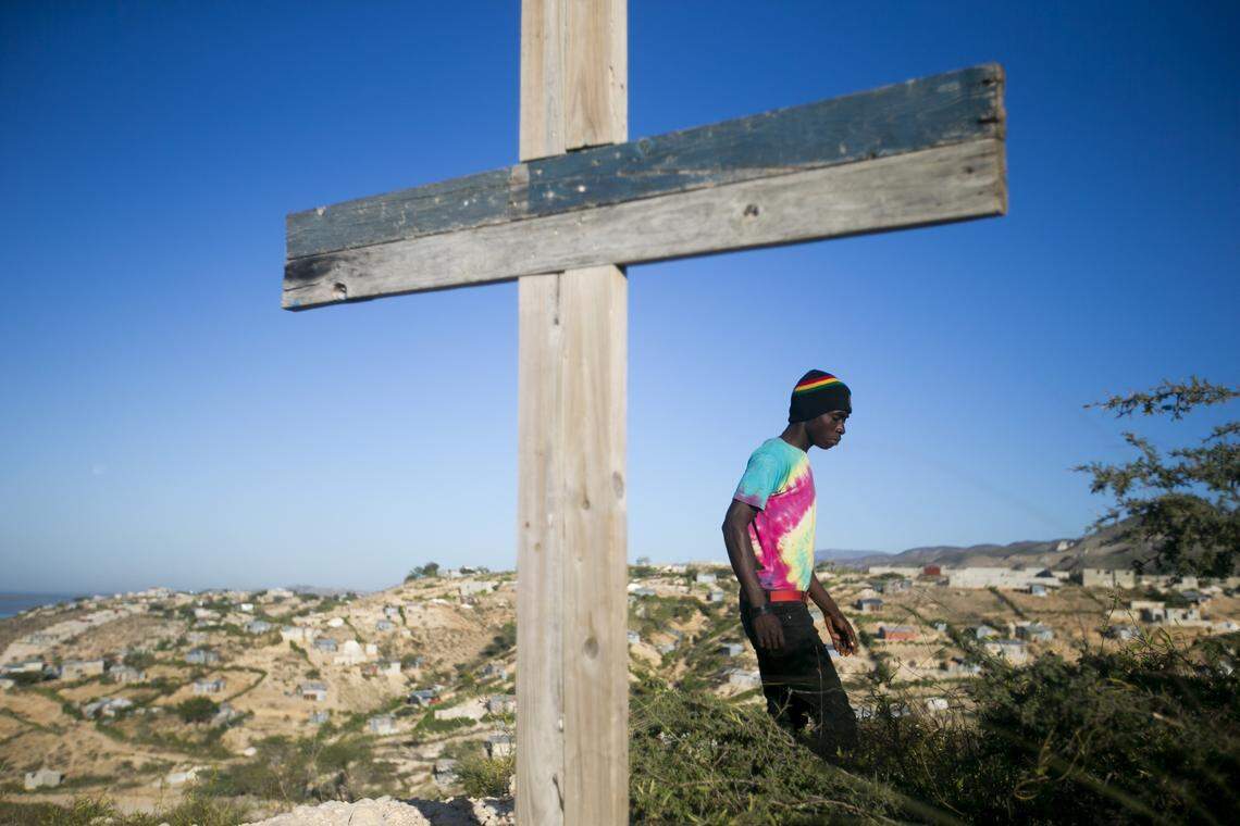 A resident walks past a cross during a memorial service honoring the victims of the 2010 earthquake, at Titanyen, a mass burial site north of Port-au-Prince, Haiti, on Sunday, Jan. 12, 2020. Sunday marked the 10th anniversary of the devastating 7.0 magnitude earthquake that killed hundreds of thousands of people and destroyed an estimated 100,000 homes across the capital and southern Haiti.