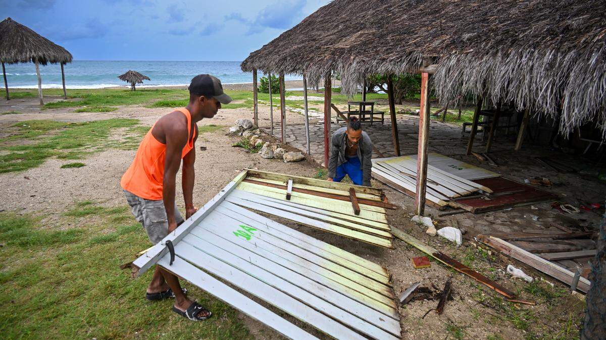 Worker dismantle parts of a tourist facility at Guama beach ahead of the arrival of Hurricane Melissa near Santiago de Cuba, Cuba, on October 28, 2025. Hurricane Melissa was set to strike nearby eastern end of Cuba late Tuesday after pummeling Jamaica. (Photo by YAMIL LAGE / AFP) (Photo by YAMIL LAGE/AFP via Getty Images)          